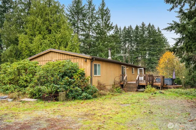 a backyard of a house with wooden fence and large trees