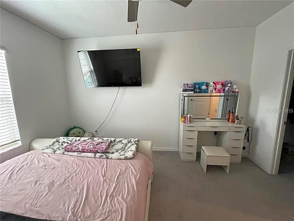 31751 Blue Passing Loop Wesley Chapel, FL 33545 - Photo 13 of 18 a bedroom with a bed and a flat screen tv