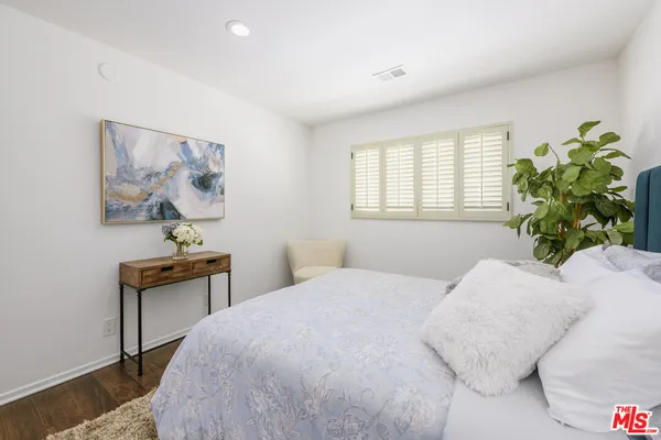 a bedroom with a bed and a painting on the wall