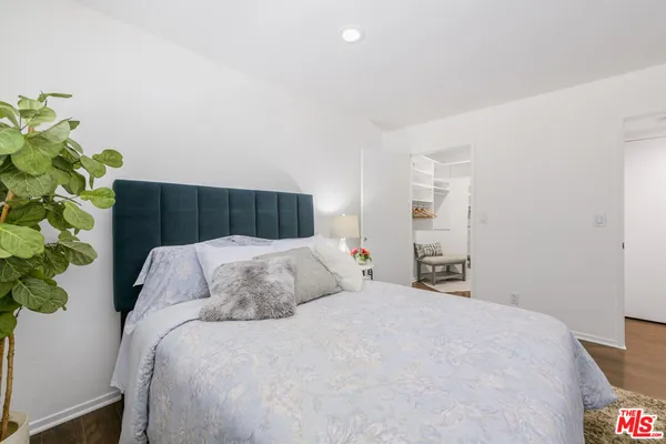 a bedroom with a bed and a potted plant