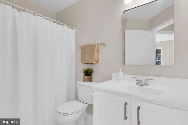 a bathroom with a sink a toilet and mirror