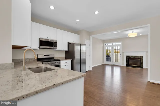 a kitchen with granite countertop a sink counter top space appliances and cabinets