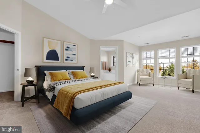 a spacious bedroom with a large bed and a chandelier