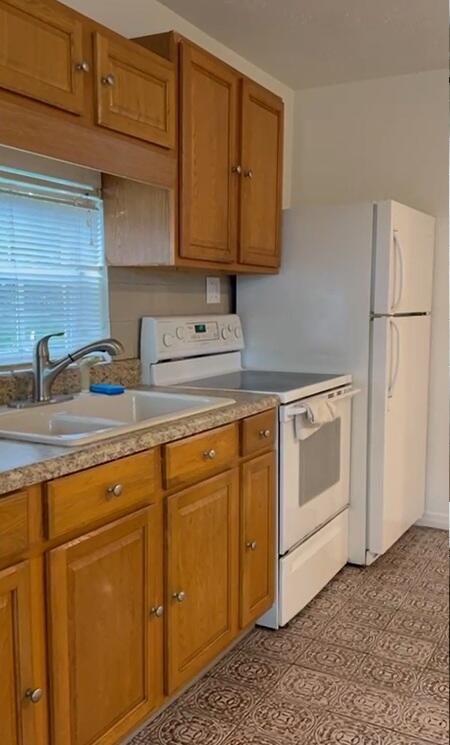 a kitchen with stainless steel appliances granite countertop a sink a stove and refrigerator