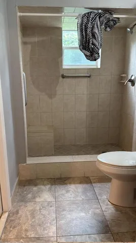 a bathroom with a toilet and a shower