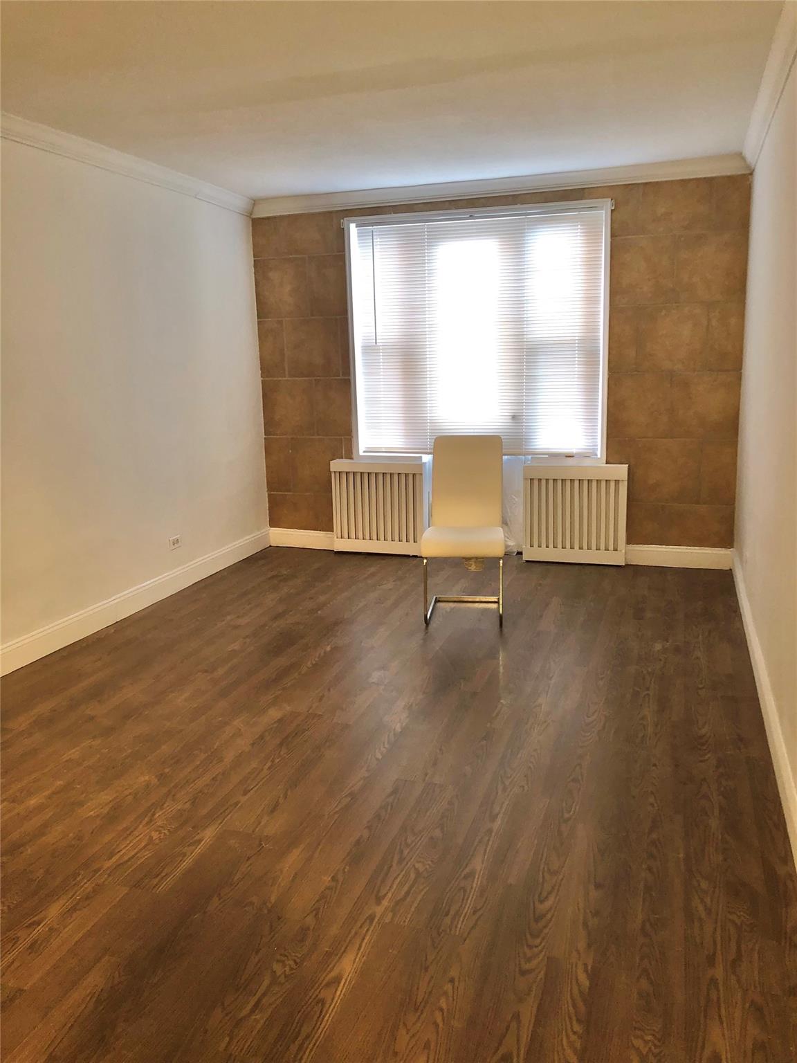 150-25 72nd Road, Unit 1E Queens, NY 11367 - Photo 4 of 7 wooden floor in an empty room with a window