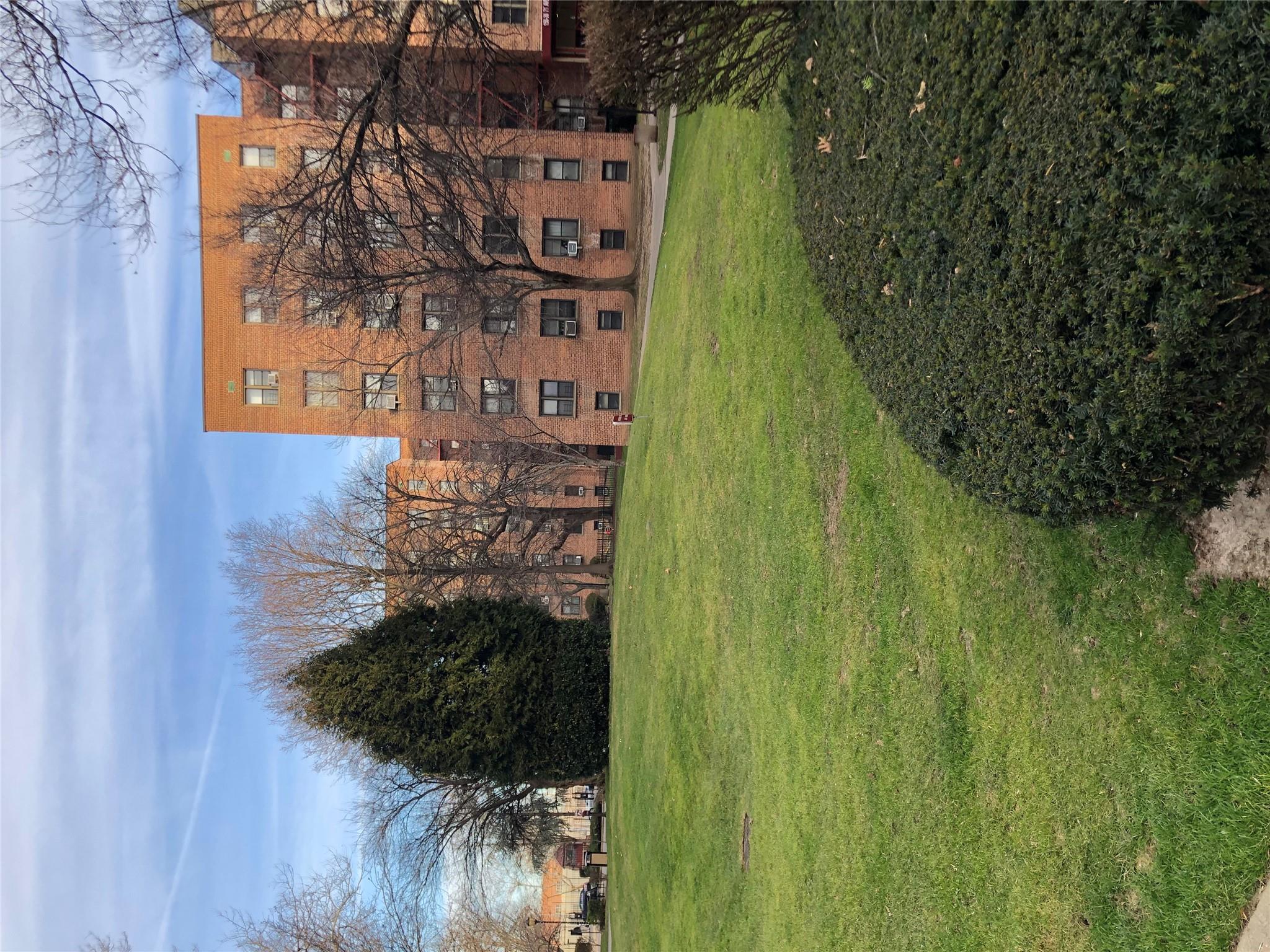 150-25 72nd Road, Unit 1E Queens, NY 11367 - Photo 7 of 7 a view of a big yard with a building in the background