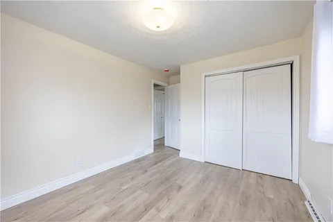 an empty room with wooden floor and closet