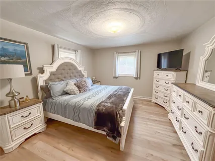 a bedroom with a bed and a flat tv screen on dresser