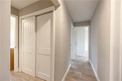 a view of a hallway with wooden floor
