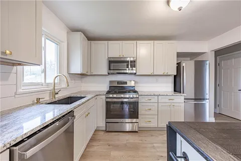 a kitchen with granite countertop a stove sink and refrigerator
