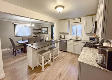 a kitchen with a sink stove and wooden floor