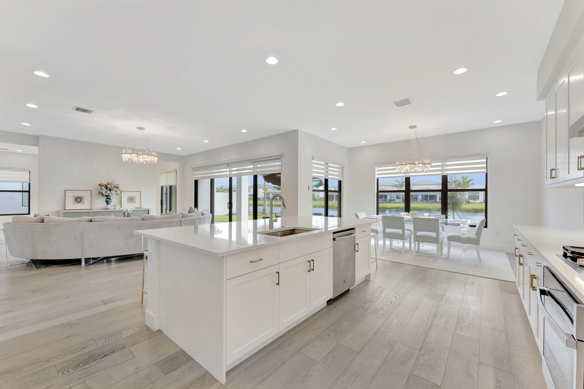 20046 Pacific Dunes Drive Boca Raton, FL 33434 - Photo 21 of 130 a large white kitchen with wooden floor and a large window