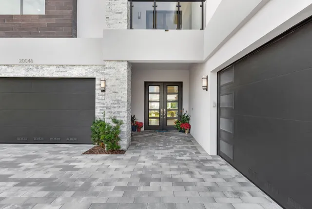 a large white kitchen with wooden floor and a large window