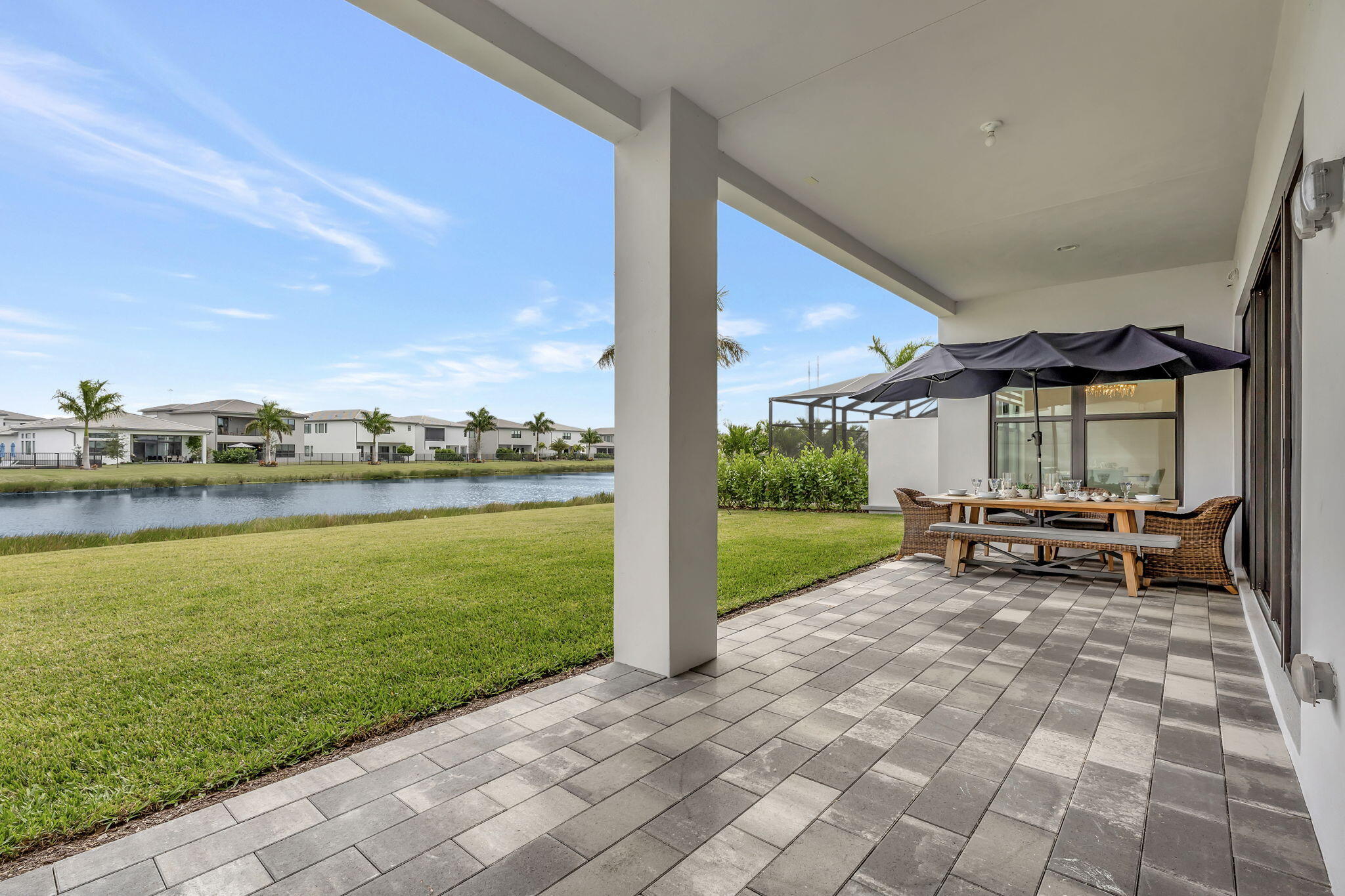 20046 Pacific Dunes Drive Boca Raton, FL 33434 - Photo 49 of 130 a view of a patio with a table and chairs next to a yard