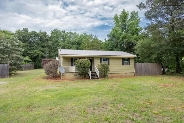 a view of a house with a yard and sitting area