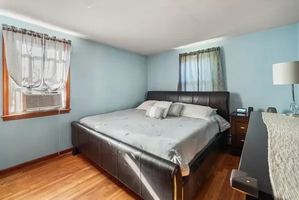 a bedroom with a bed and wooden floor