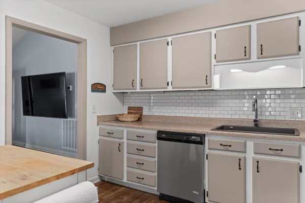 a kitchen with cabinets appliances a sink and a counter top space