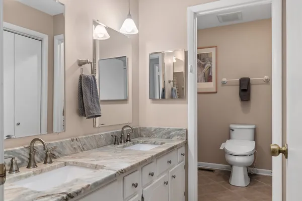 a bathroom with a granite countertop sink mirror and toilet