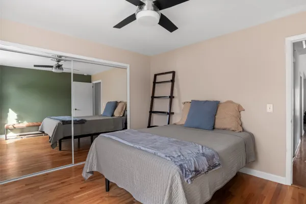 a bedroom with a bed and wooden floor