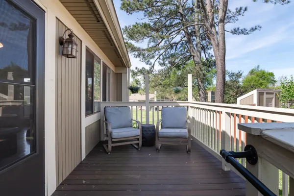a view of a balcony with chairs and a barbeque