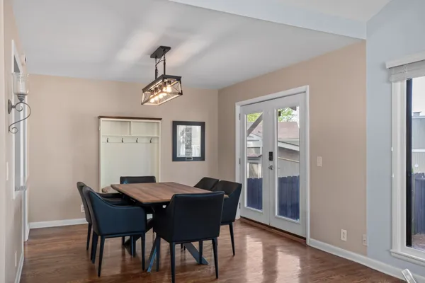 a dining room with furniture a chandelier and wooden floor