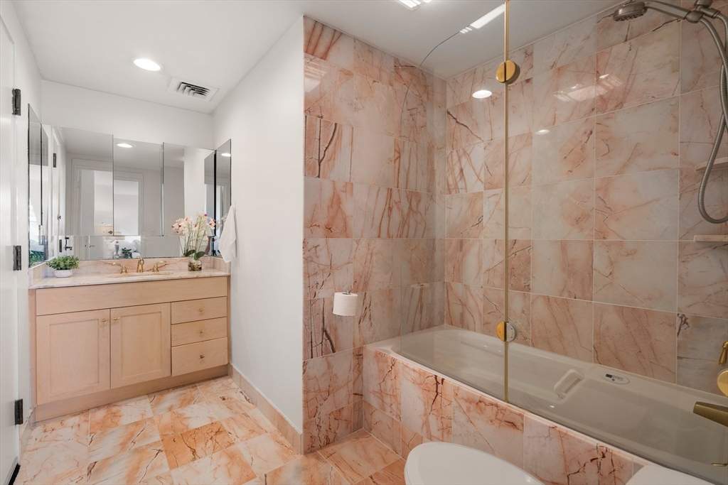 56 Ober Road, Unit 56 Newton, MA 02459 - Photo 21 of 27 a bathroom with a granite countertop sink mirror bathtub and shower