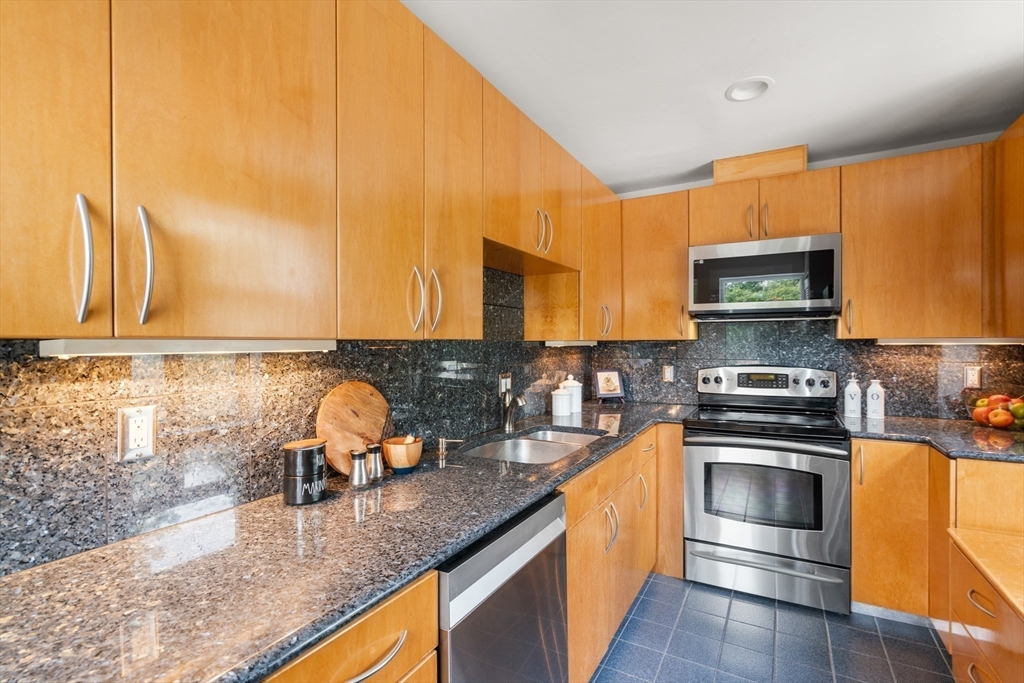 56 Ober Road, Unit 56 Newton, MA 02459 - Photo 4 of 27 a kitchen with stainless steel appliances granite countertop a stove a sink and a microwave