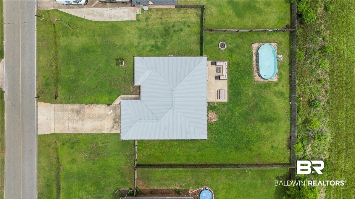 8952 Sherman Road Foley, AL 36535 - Photo 6 of 41 Expansive fenced backyard featuring a swimming pool, concrete patio, and a fire pit