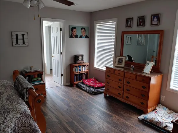 a bedroom with bed and wooden floor