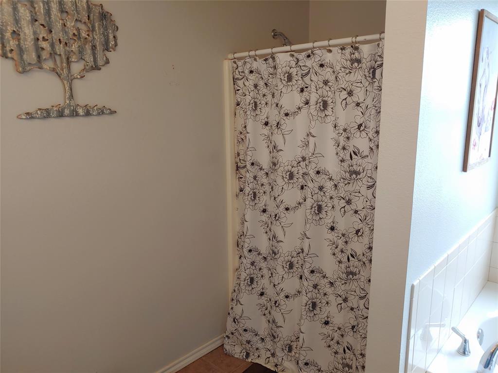 84 County Road Sumner, TX 75486 - Photo 24 of 33 a bathroom with a shower curtain