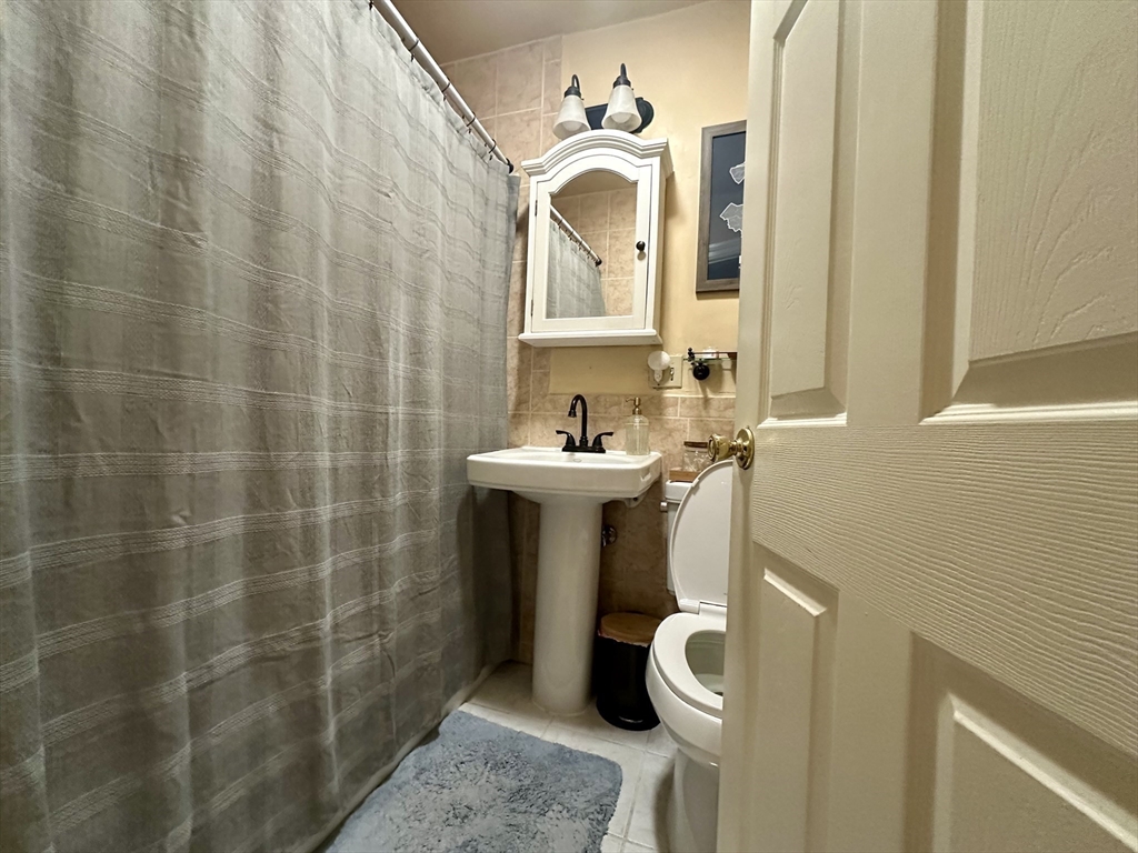 9 Leverett Street, Unit 3 Brookline, MA 02445 - Photo 8 of 8 a bathroom with a sink a toilet and shower curtain