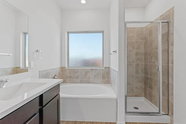 a bathroom with a tub a double vanity sink and mirror