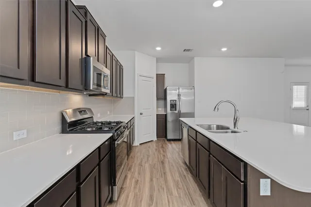 a kitchen with stainless steel appliances granite countertop a sink stove and cabinets