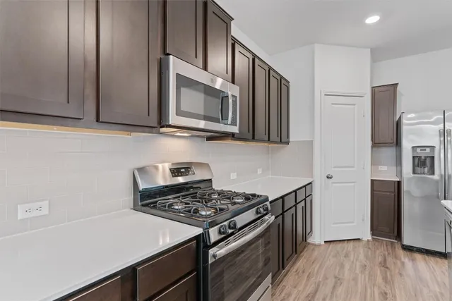 a kitchen with stainless steel appliances granite countertop a stove microwave and refrigerator