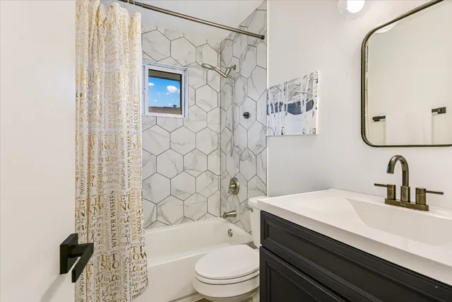 a bathroom with a sink a toilet and shower curtain