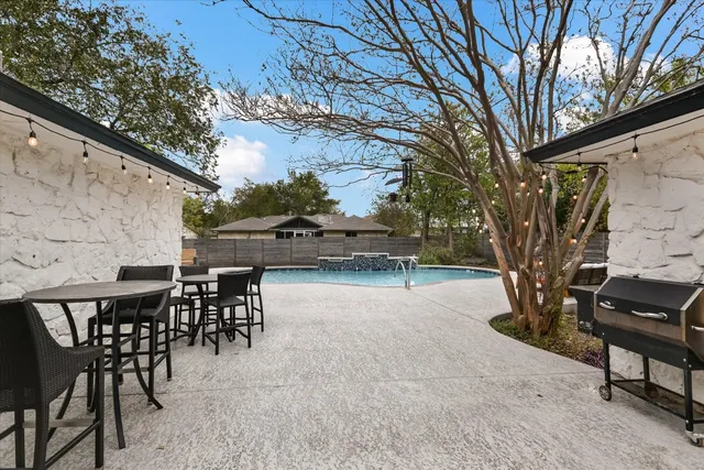 a backyard of a house with table and chairs