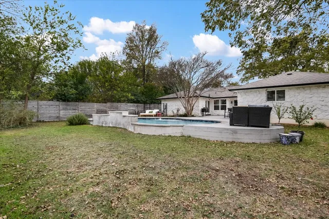 a view of a house with backyard and sitting area