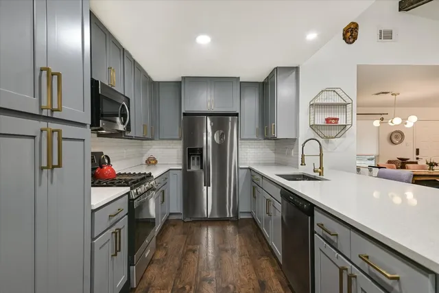 a kitchen with stainless steel appliances granite countertop a sink stove and refrigerator