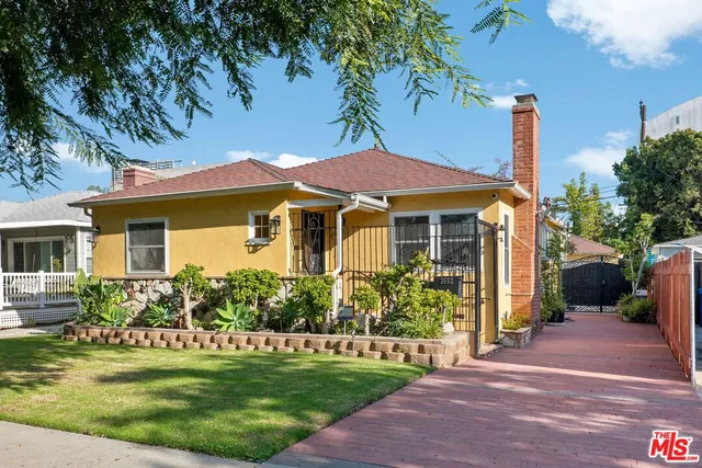 a front view of a house with a garden and plants