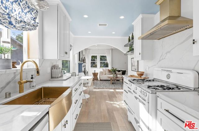 a kitchen with stainless steel appliances granite countertop a sink stove and cabinets