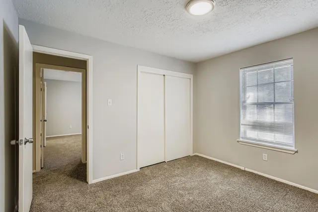 an empty room with windows and closet