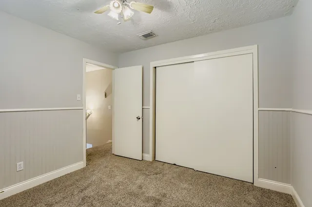 an empty room with chandelier fan