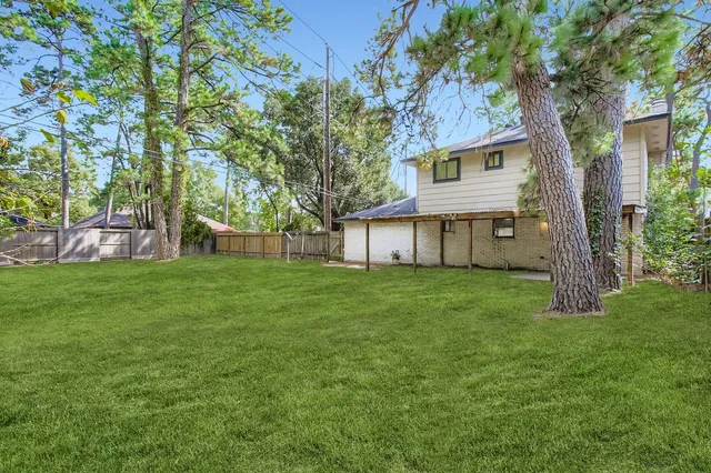 a view of a house with backyard and a tree