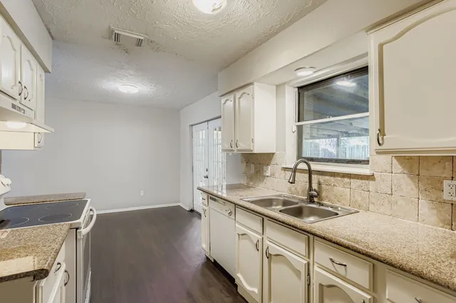 a kitchen with a sink stove and cabinets