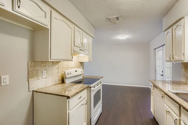 a kitchen with a sink stove and cabinets