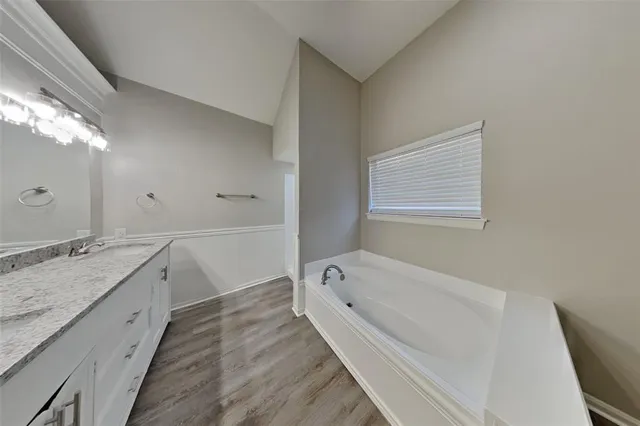a spacious bathroom with a granite countertop tub sink and mirror