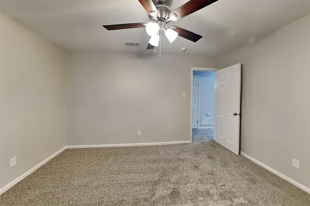 an empty room with chandelier fan