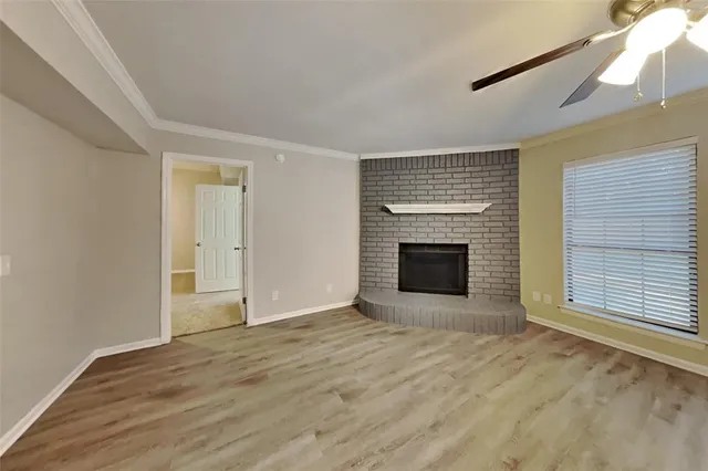 a view of an empty room with a fireplace and a window
