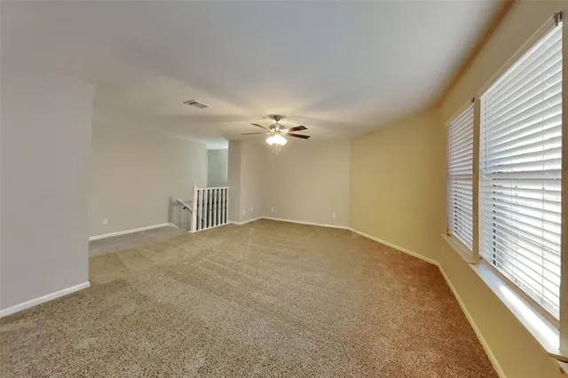 a view of a livingroom with a ceiling fan and window